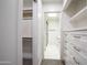 Open walk-in closet leading to a bathroom with white cabinets at 4525 N 66Th St # 95, Scottsdale, AZ 85251