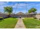 Spacious backyard featuring a stone pathway, grassy area, and string lights at 4595 W Foldwing Dr, San Tan Valley, AZ 85144