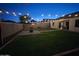 A spacious backyard with green grass, a cozy patio, and decorative string lights at 4595 W Foldwing Dr, San Tan Valley, AZ 85144