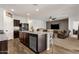 Open kitchen with granite countertops, wood floors, and stainless steel appliances overlooks the living area at 4595 W Foldwing Dr, San Tan Valley, AZ 85144