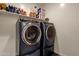 Laundry room with modern washer and dryer with storage shelf and wood-style flooring at 4595 W Foldwing Dr, San Tan Valley, AZ 85144