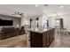 Open floor plan showcasing a kitchen island with granite countertops and an adjacent living and dining area at 4595 W Foldwing Dr, San Tan Valley, AZ 85144