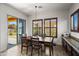 A dining room with wood table and chairs, light fixture, shutters, and a sliding glass door at 4721 N Aldea W Rd, Litchfield Park, AZ 85340