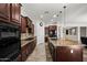 Large kitchen with an island, stainless steel appliances, granite countertops, and dark wood cabinets, great for cooking at 4721 N Aldea W Rd, Litchfield Park, AZ 85340