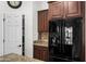 View of a kitchen with stainless steel refrigerator, dark cabinets, and a granite countertop, offering modern convenience at 4721 N Aldea W Rd, Litchfield Park, AZ 85340