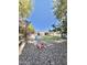Spacious backyard with lush lawn, patio area, and toy car on a stone yard at 4838 W Christine Cir, Glendale, AZ 85308