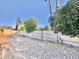 Open gravel backyard featuring a cinder block fence with greenery and trees behind it at 4838 W Christine Cir, Glendale, AZ 85308