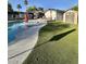 Backyard pool with artificial turf, lounge chairs, and storage shed, offering a relaxing outdoor space at 4838 W Christine Cir, Glendale, AZ 85308