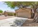 Exterior shot of a home featuring a two-car garage, desert landscaping and mature shade trees at 5439 W Sands Rd, Glendale, AZ 85301
