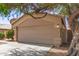 Exterior shot of a home featuring a two-car garage, desert landscaping and mature shade trees at 5439 W Sands Rd, Glendale, AZ 85301