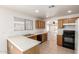 Sunlit kitchen with tile floors and light wood cabinets plus a view into the adjacent room at 5439 W Sands Rd, Glendale, AZ 85301
