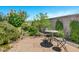 Private backyard with stone patio and mosaic table set, surrounded by lush landscaping at 6145 S Adelle --, Mesa, AZ 85212