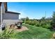 Backyard featuring lush green grass, stone patio, comfortable seating and garden area at 6145 S Adelle --, Mesa, AZ 85212