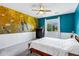 The main bedroom features an accent wall with wainscotting, a ceiling fan and a plush bed at 6145 S Adelle --, Mesa, AZ 85212