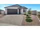 Inviting single-story home with a grey garage, desert landscaping, and a beautiful paver driveway at 6145 S Adelle --, Mesa, AZ 85212