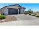 Lovely single-story home boasts a grey garage, desert landscaping, and a spacious paved driveway at 6145 S Adelle --, Mesa, AZ 85212