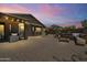 Charming backyard featuring a stone fire pit with built-in benches, a covered seating area, and professional hardscape at 6213 W Gambit Trl, Phoenix, AZ 85083