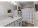Well-lit bathroom featuring a modern vanity, stylish mirror, and shower with a decorative curtain at 6213 W Gambit Trl, Phoenix, AZ 85083