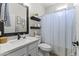 Charming bathroom featuring a marble countertop, decorative shelves, and a shower with a stylish curtain at 6213 W Gambit Trl, Phoenix, AZ 85083