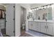 Bright bathroom with double vanity, mirrors, and walk-in closet at 6213 W Gambit Trl, Phoenix, AZ 85083