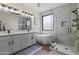 Bright bathroom featuring double sinks, a soaking tub, a frameless shower, and elegant tile work at 6213 W Gambit Trl, Phoenix, AZ 85083