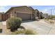 Side angle showing a two-car garage and xeriscaping of this single-story stucco house at 6213 W Gambit Trl, Phoenix, AZ 85083
