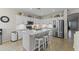Modern kitchen with white cabinets, stainless steel appliances, island with bar stools and tile flooring at 6213 W Gambit Trl, Phoenix, AZ 85083