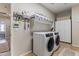 Efficient laundry room with modern washer/dryer set, storage cabinets, and a well-organized shelving system for convenience at 6213 W Gambit Trl, Phoenix, AZ 85083