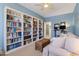 Inviting living room featuring a built-in bookshelf, a comfortable sofa and a dedicated office area, creating a functional and stylish space at 6213 W Gambit Trl, Phoenix, AZ 85083