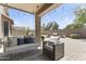 Cozy covered patio featuring a cushioned swing, comfortable wicker chair, and elegant string lights for relaxing outdoor living at 6213 W Gambit Trl, Phoenix, AZ 85083