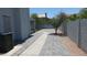 Long driveway with pavers leading to backyard with lawn and well maintained perimeter fence at 627 W Mendoza Ave, Mesa, AZ 85210
