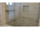 Modern shower with glass door, neutral tile, built-in niche, and brushed nickel hardware at 627 W Mendoza Ave, Mesa, AZ 85210