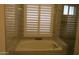 Soaking tub and frameless shower combination with window and shutter at 627 W Mendoza Ave, Mesa, AZ 85210