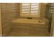 Relaxing bathroom with tub, tiled walls, and shutters allowing natural light at 627 W Mendoza Ave, Mesa, AZ 85210