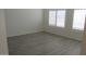 Bright bedroom with ample natural light, white walls, white shutters, and wood-look flooring at 627 W Mendoza Ave, Mesa, AZ 85210