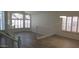 Bright living room featuring abundant natural light, white walls, wood-look flooring, and white railings at 627 W Mendoza Ave, Mesa, AZ 85210