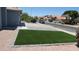 This home features a neatly landscaped front yard with low-maintenance artificial grass and neighborhood street view at 627 W Mendoza Ave, Mesa, AZ 85210