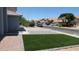 Home with artificial grass lawn, stone-lined driveway and manicured rock beds in quiet residential neighborhood at 627 W Mendoza Ave, Mesa, AZ 85210