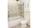 Bathroom featuring a tub, glass shower, neutral tile, and modern fixtures at 6436 W Saddlehorn Rd, Phoenix, AZ 85083