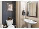 Stylish powder room featuring elegant wallpaper, pedestal sink, and decorative accents at 70 E Kennedia Dr, Queen Creek, AZ 85140