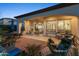 Expansive covered patio area with multiple seating areas, fireplace, and lush landscaping at 70 E Kennedia Dr, Queen Creek, AZ 85140