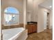 Primary bathroom features a soaking tub, a vanity with granite counters and large window at 7101 W Beardsley Rd # 1502, Glendale, AZ 85308