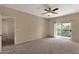 Large, carpeted bedroom featuring a ceiling fan and a sliding glass door to the balcony at 7101 W Beardsley Rd # 1502, Glendale, AZ 85308
