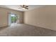 A carpeted bedroom featuring a ceiling fan and sliding glass door leading to a balcony at 7101 W Beardsley Rd # 1502, Glendale, AZ 85308