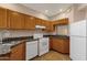 Functional kitchen featuring granite countertops, wood cabinets, and modern white appliances, creating a cozy cooking space at 7101 W Beardsley Rd # 1502, Glendale, AZ 85308