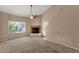 Cozy living room area featuring a corner fireplace, a large window, and easy access to an outdoor patio at 7101 W Beardsley Rd # 1502, Glendale, AZ 85308