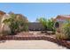 Backyard with stone retaining wall, lush landscaping, mature shade trees, and low-maintenance patio at 725 W Beth Dr, Phoenix, AZ 85041