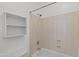 Clean bathroom with a white tub, updated fixtures, and built-in shelving for convenient storage at 725 W Beth Dr, Phoenix, AZ 85041