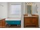 Stylish bathroom featuring a clawfoot tub, white vanity, and a bright glass block window at 725 W Beth Dr, Phoenix, AZ 85041
