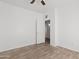 Minimalist bedroom with wood-look floors, a ceiling fan, and a doorway leading to another room at 725 W Beth Dr, Phoenix, AZ 85041